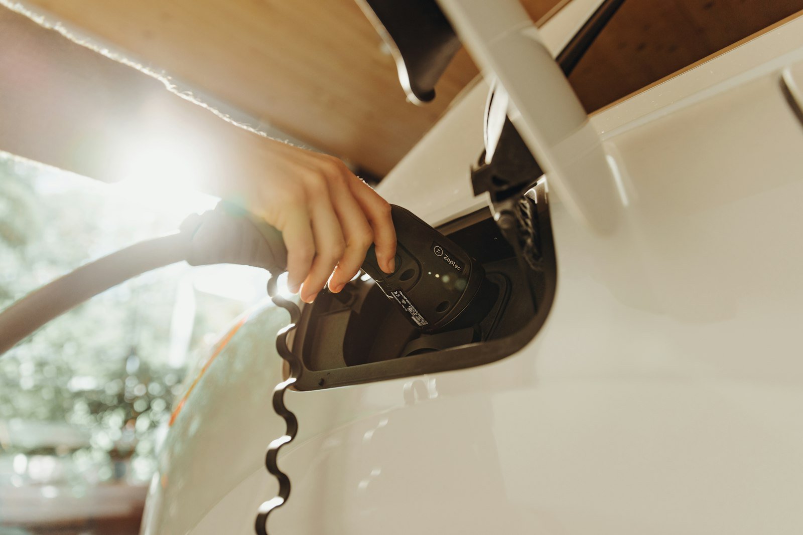Lithium vs. Lead-Acid Golf Cart Batteries: What Actually Changes Hand plugging a charging cable into an electric vehicle
